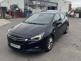 une Opel noire garée sur un parking à côté d'un immeuble