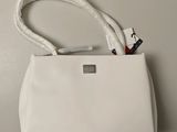 the white purse is sitting on the table next to the white bag