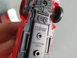 a person holding a red toy car in their hand