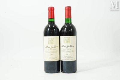 deux bouteilles de vin rouge posées l'une à côté de l'autre sur une surface blanche