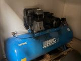 a blue air compressor sitting on a pallet in a room