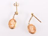 an image of a pair of earrings with a woman ' s face on them