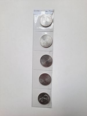quatre types de pièces différents sont présentés sur une surface blanche