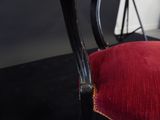 a red chair with a black frame and a red cushion