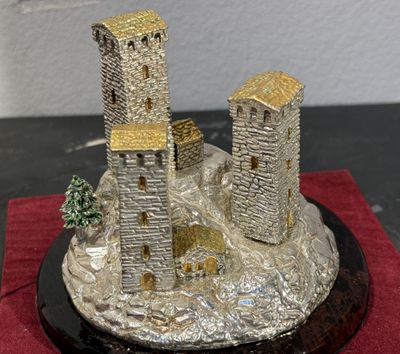 statue représentant un château sur un rocher, avec un arbre devant