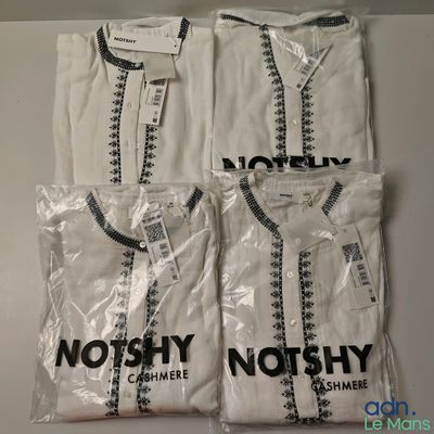 Trois t-shirts blancs avec des logos en noir et blanc sont posés sur une table