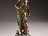 an antique bronze statue of a woman holding a bird on a marble base