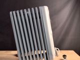 un radiateur posé sur une table en bois, à côté d'une bouteille d'eau