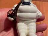 une petite figurine représentant un homme tenant une pipe à la main