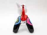 a colorful cat figurine sitting on a white surface