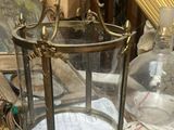 une lanterne en verre posée sur une table, à côté d'autres objets