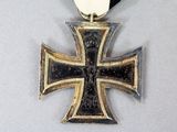 a silver and gold cross on a black ribbon