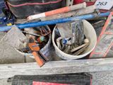 a bucket full of tools sitting on the ground