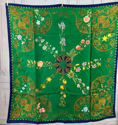 a green and blue scarf with a floral design on it