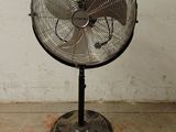 un ventilateur posé sur un support dans une pièce