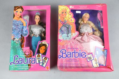 two barbie dolls are in a pink box on a gray surface