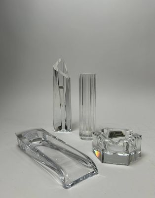 trois objets en verre transparent posés sur une surface blanche