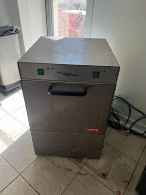 un lave-vaisselle argenté posé sur un sol carrelé dans une cuisine