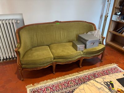 a green couch in a living room with a rug on the floor