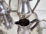 a silver tray with a silver tea set on it
