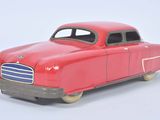 a red toy car that is sitting on a white surface