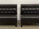 une paire de fauteuils en cuir noir avec des boutons sur le dossier