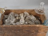 a wooden box filled with glass bottles on a white surface