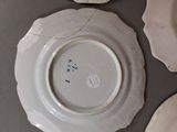 four white plates are arranged on a table with a black background