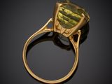 a close up of a ring with a green stone on it