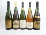 six bouteilles de vin sont alignées sur une surface blanche