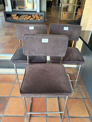 three chairs sitting on a tiled floor in front of a fire place