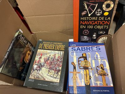 de nombreux livres dans une boîte, posés sur une table