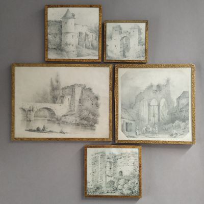 four framed drawings of a castle on a wall above a bed