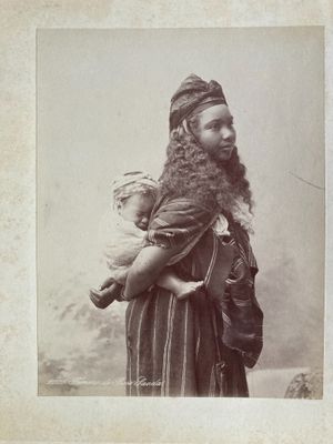 an old photo of a man with a beard holding a baby