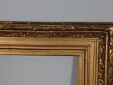an image of a gold framed mirror on a wall in a room