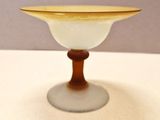 un petit bol en verre posé sur une table, avec un socle en bois