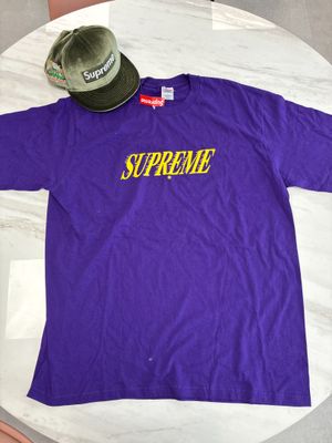 purple supreme t - shirt with yellow supreme logo on the chest