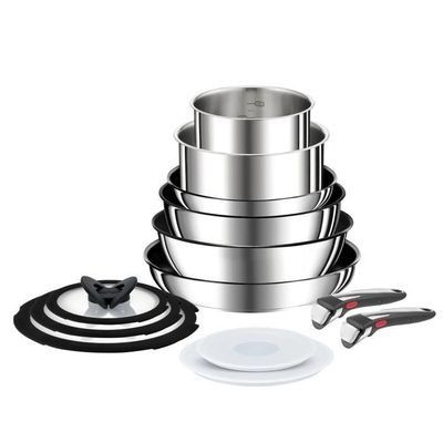 une pile de casseroles et de poêles en acier inoxydable posée sur une table