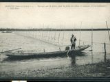 une vieille photo montrant deux hommes dans un bateau sur l'eau