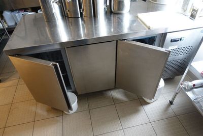 un plan de travail en acier inoxydable avec une porte ouverte dans une cuisine