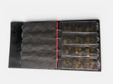 a black binder with coins in it on a white surface