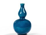 un vase bleu posé sur une surface blanche