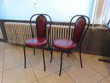 two red chairs sitting next to a radiator in a room