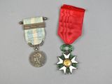 deux médailles et une médaille posée sur une table, à côté d'une pièce de monnaie