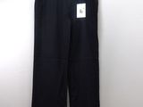 black pants hanging on a hanger against a white wall