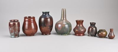 de nombreux vases de différentes couleurs posés sur une surface blanche