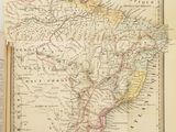 une vieille carte de l'Amérique du Sud, avec un livre ouvert sur une page où figure une carte