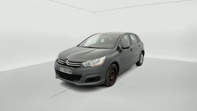 Une voiture grise est garée dans une pièce blanche.