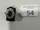 Gros plan sur une bague ornée d'une pierre verte
