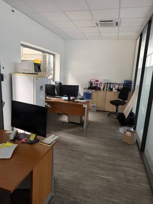 an image of an office with a desk and a refrigerator